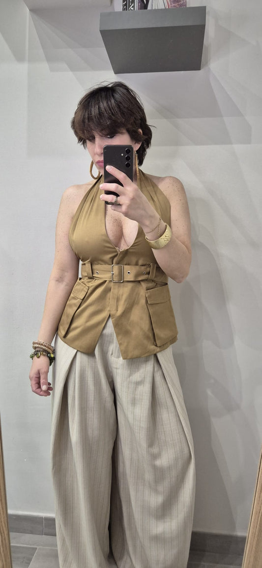 Donna indossa top scollato beige con cintura e pantaloni larghi a righe, stile moda donna elegante.