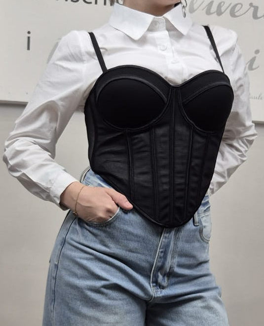 Donna con camicia bianca, bustino nero trendy e jeans a vita alta