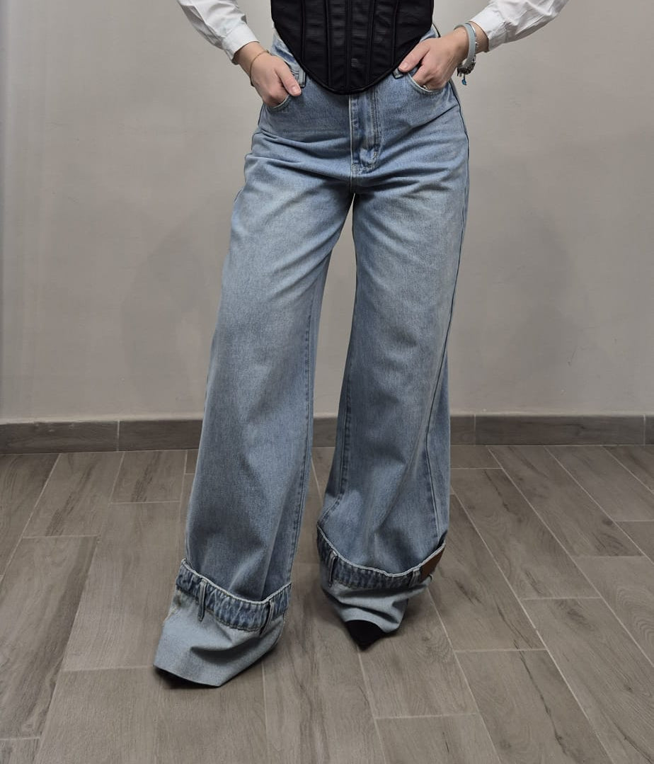 Jeans donna a gamba larga con risvolto, look casual di tendenza su pavimento chiaro