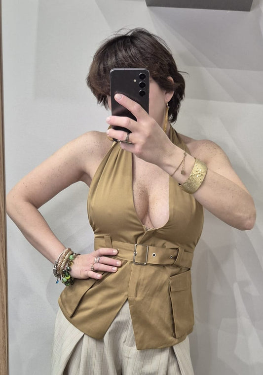 Top donna beige scollato con cintura, pantaloni chiari eleganti, bracciali oro